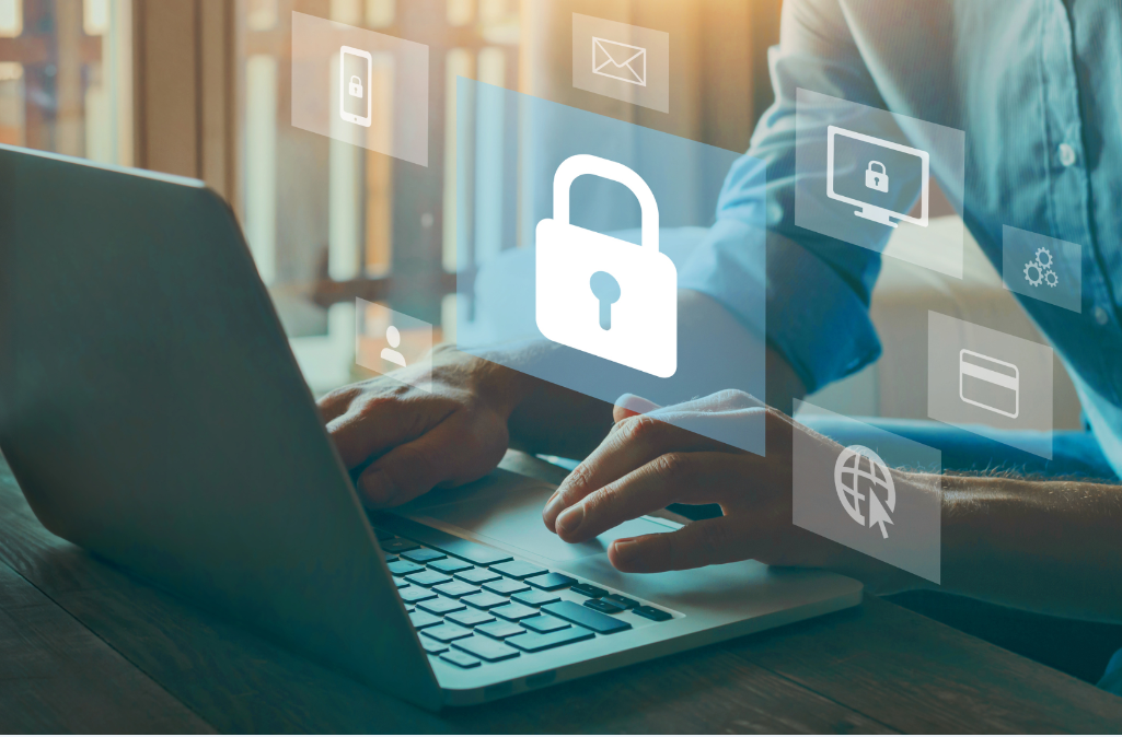 Person typing on laptop with cybersecurity symbols popping off the screen.