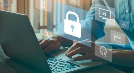 Person typing on laptop with cybersecurity symbols popping out of screen.