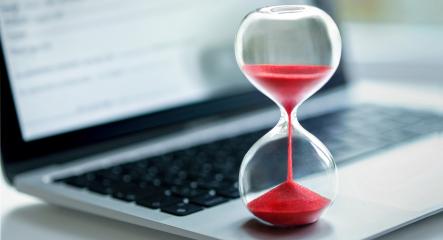 A red hourglass on laptop computer.